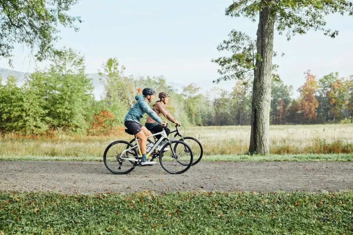 two people on bikes riding through nature