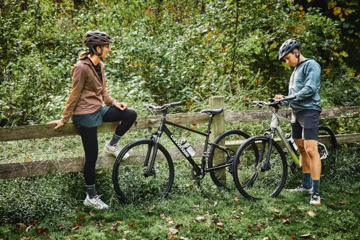 two people having a break in the forest from riding their bikes