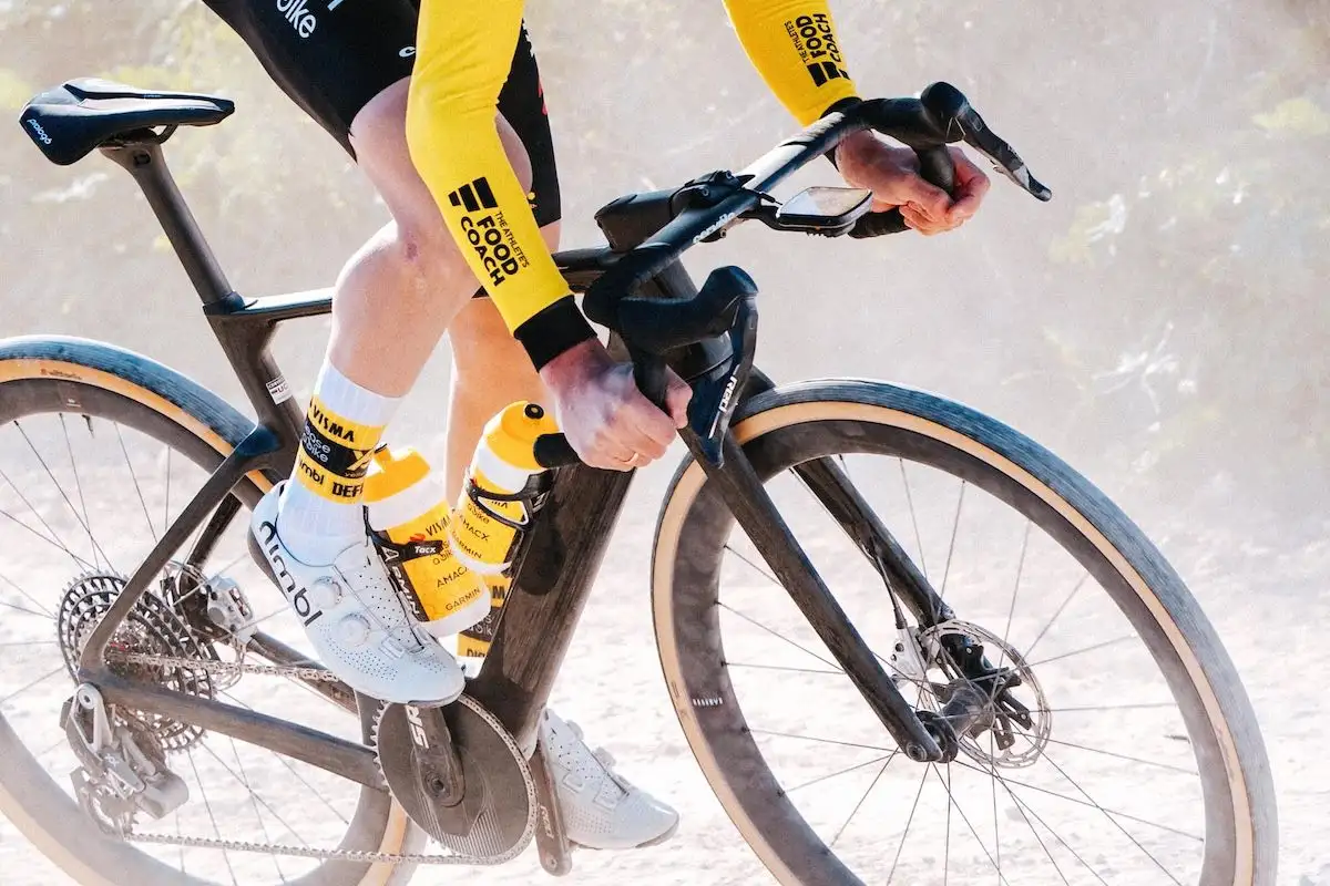 Rennradfahrer fährt mit Gravelbike über staubigen Weg