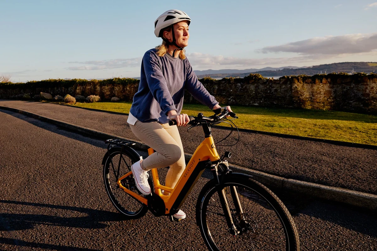 Frau auf E-Bike auf Radweg im Sommer