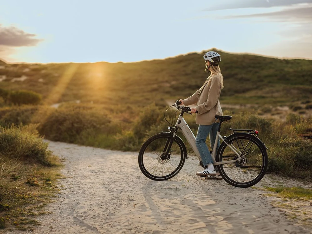 Frau mit Fahrrad vor Sonnenuntergang