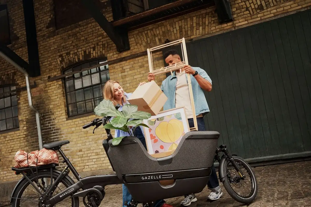 Mann und Frau stehen hinter voll gepacktem Gazelle Lastenrad