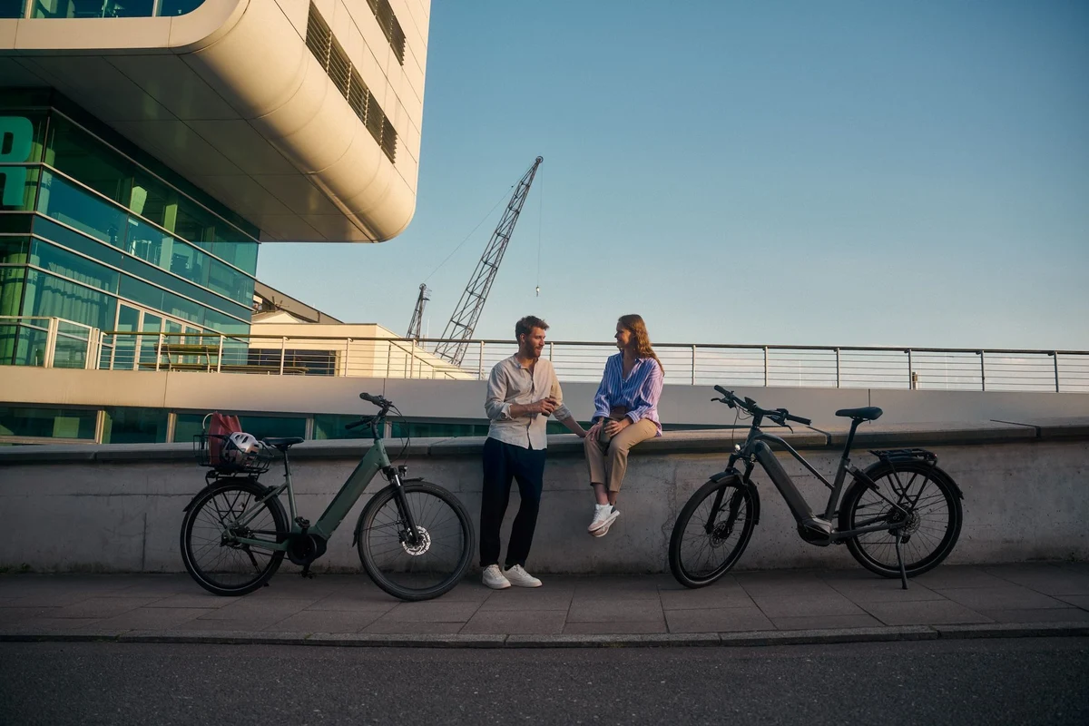 Man and woman sitting on wall, bikes parking next to them