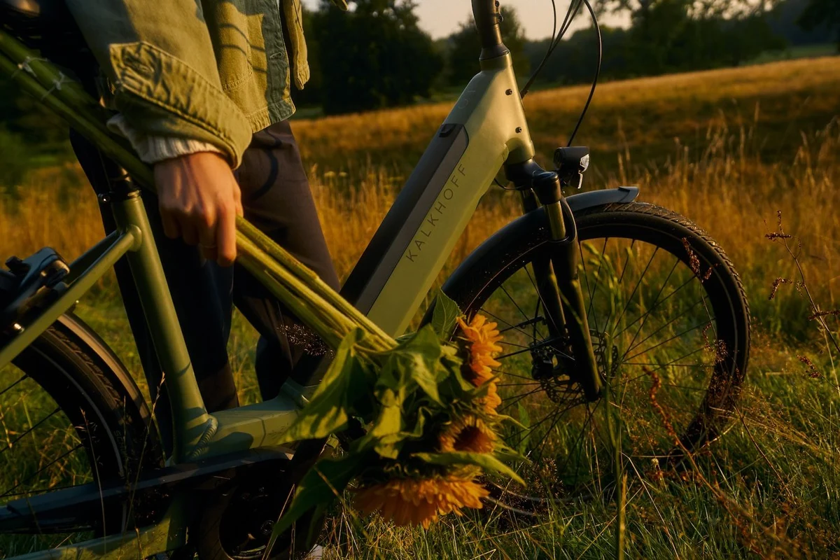 Kalkhoff Fahrrad Detail Frau mit Sonnenblumen in der Hand steht dahinter