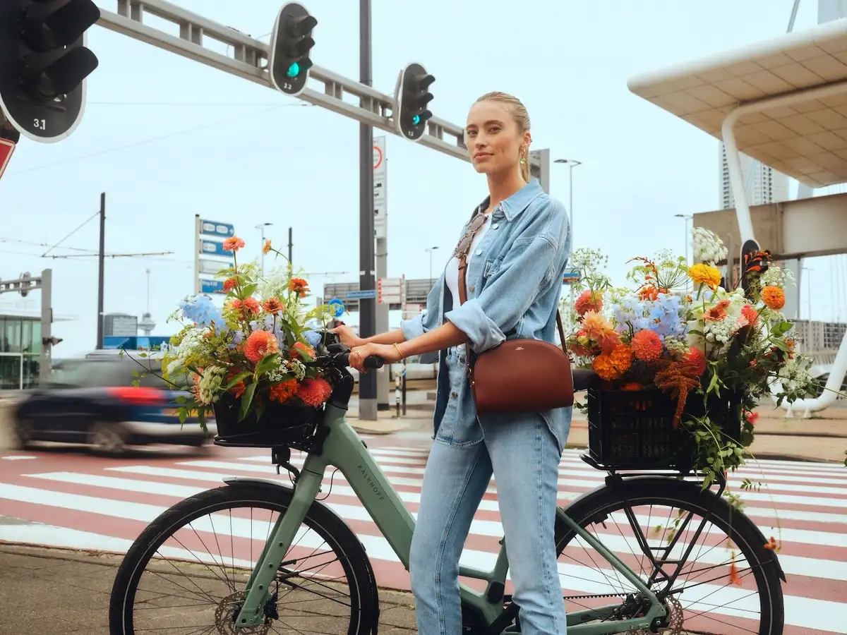 Kalkhoff Fahrrad Frau mit Blumen in Großstadt