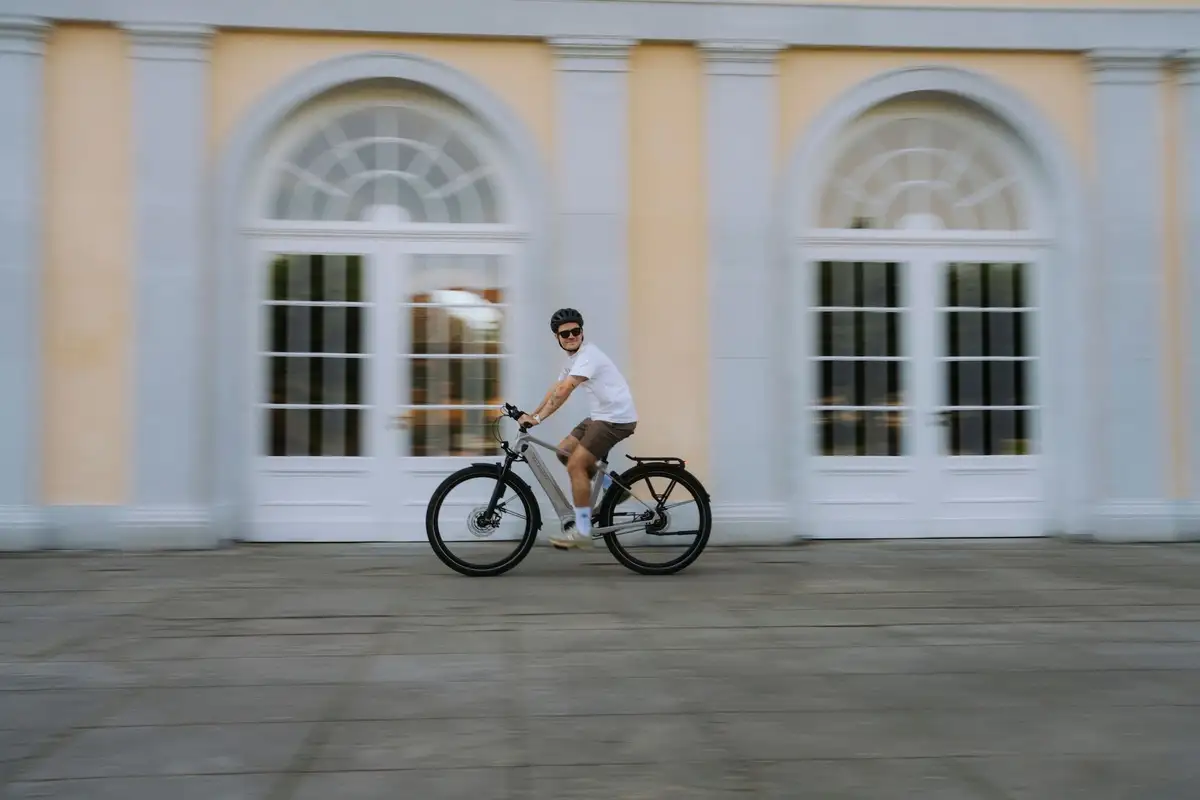 Kalkhoff Mann auf Fahrrad fährt vor Schloss