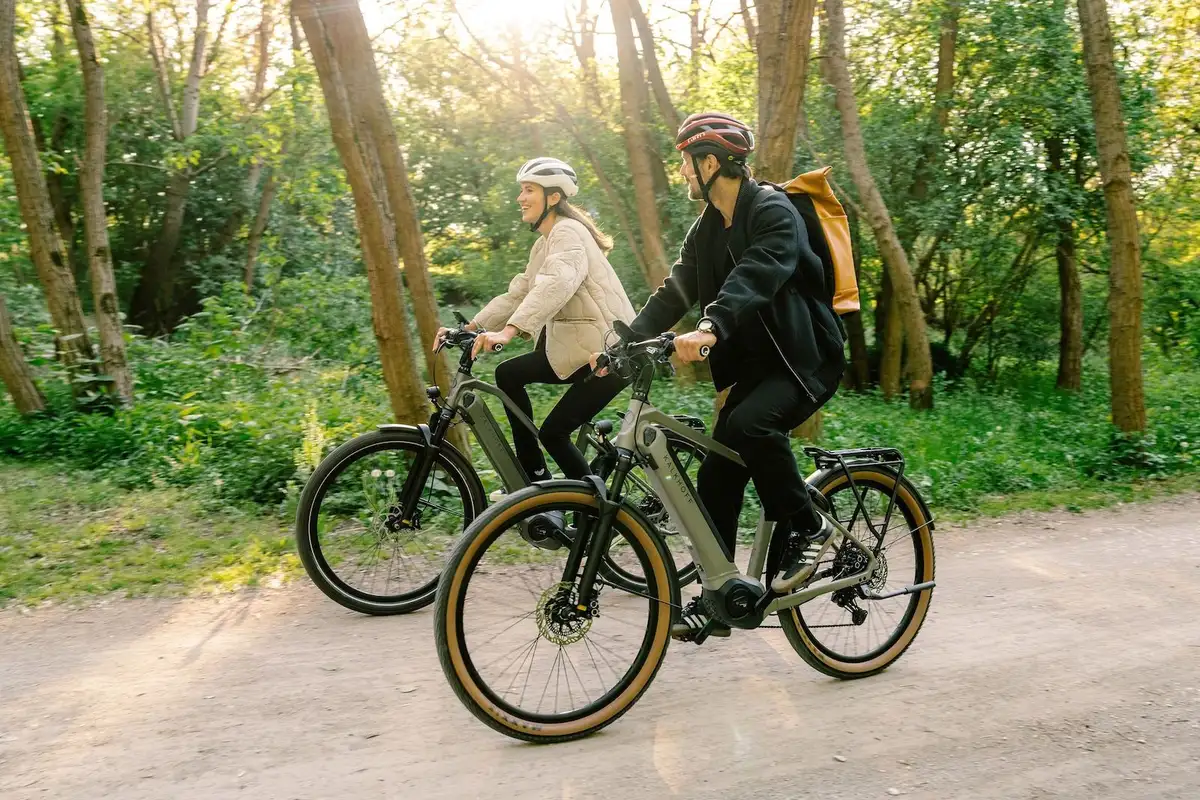 Paar auf Rädern mit Helmen im Wald