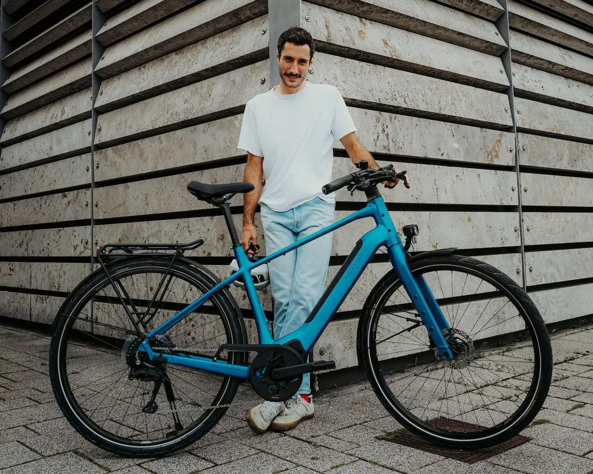 Mann steht mit blauen e-bike
