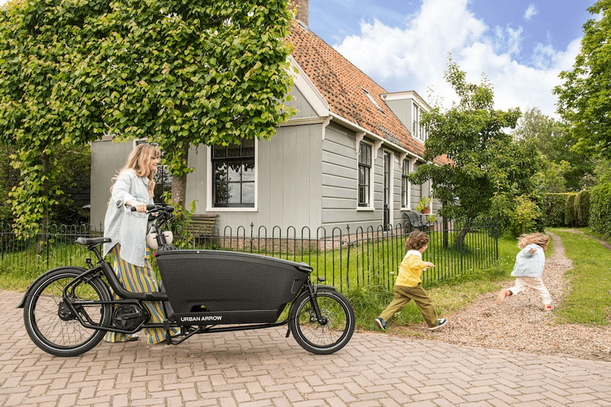 Frau mit Lastenrad und Kindern