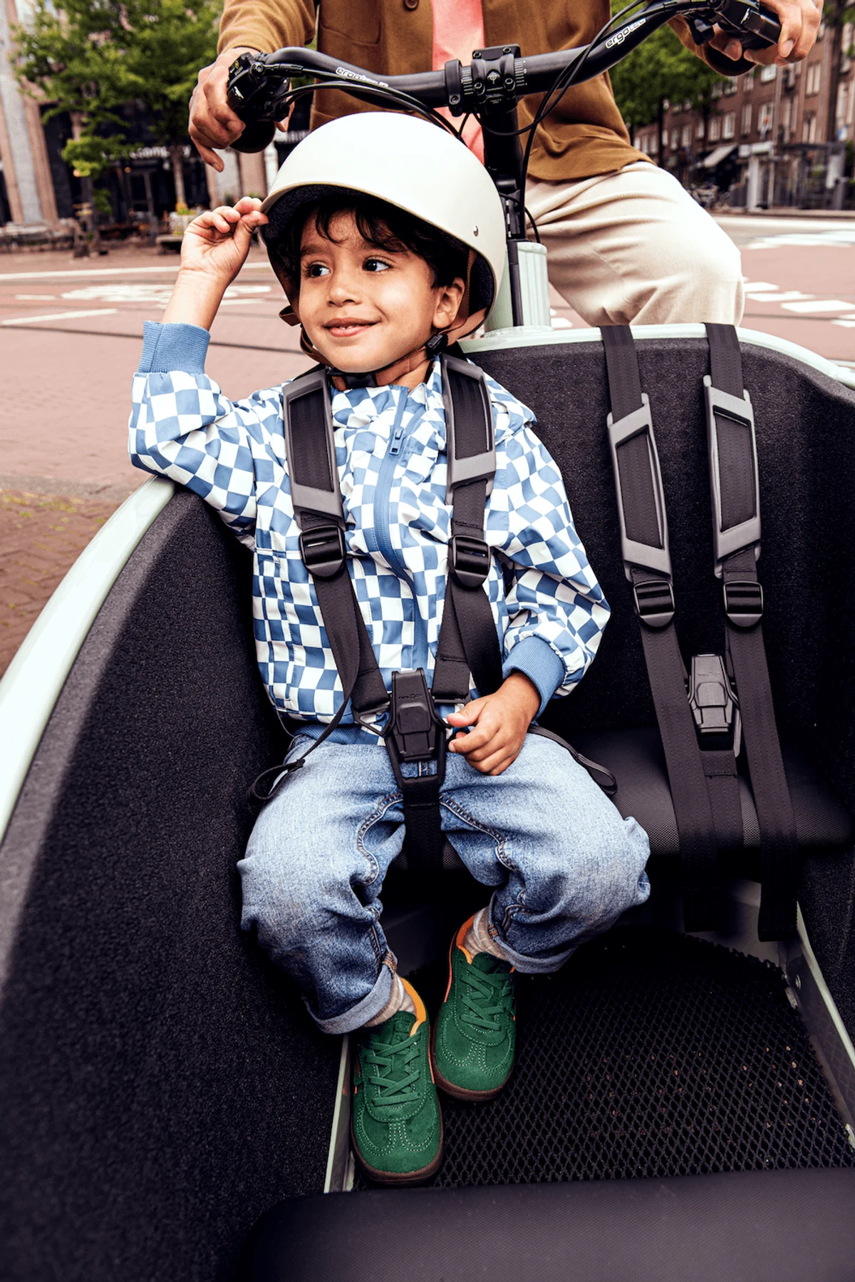 Young boy sitting in cargo bike smiling