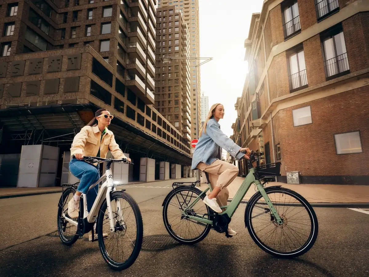 Zwei Frauen fahren mit E-Bike durch Stadt